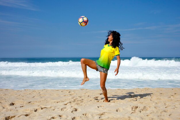 Mujer jugando a la pelota en la playa