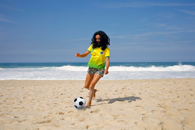 Mujer jugando a la pelota en la playa