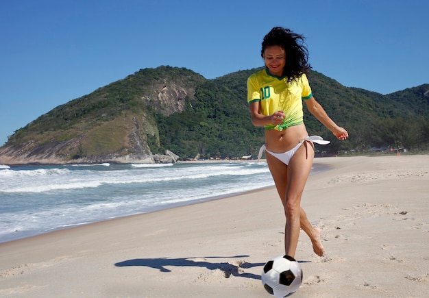 Mujer jugando a la pelota en la playa