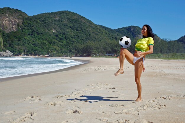 Mujer jugando a la pelota en la playa