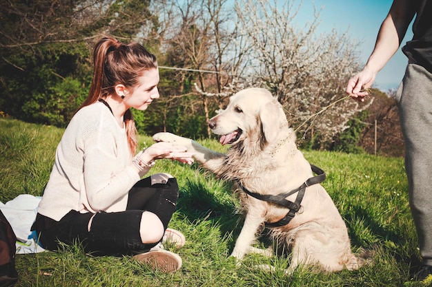 Foto mujer jugando con el perro en el campo de hierba