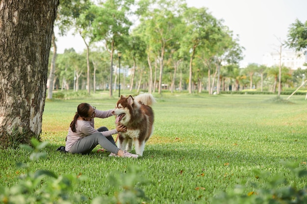 Mujer jugando con perro en el parque