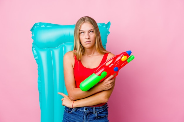 mujer jugando con una pistola de agua con un colchón de aire