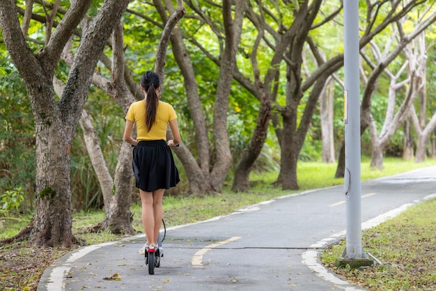 Mujer jugando con scooter en el parque