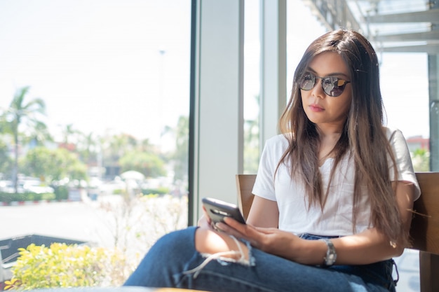 Mujer jugando smartphone, escribiendo teléfono y enviando mensaje