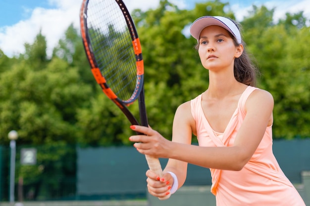 Mujer jugando tenis y esperando el servicio