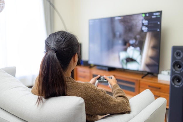 Mujer jugando videojuegos en casa