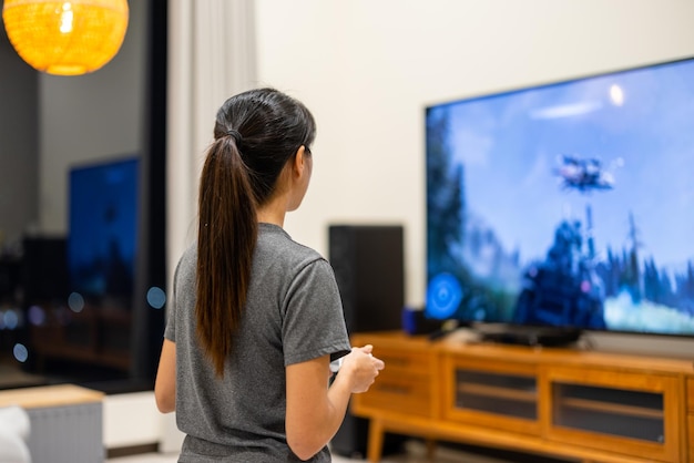 Mujer jugando videojuegos en la TV en casa