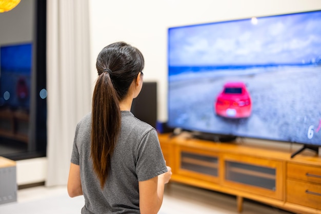 Mujer jugando videojuegos en la TV en casa