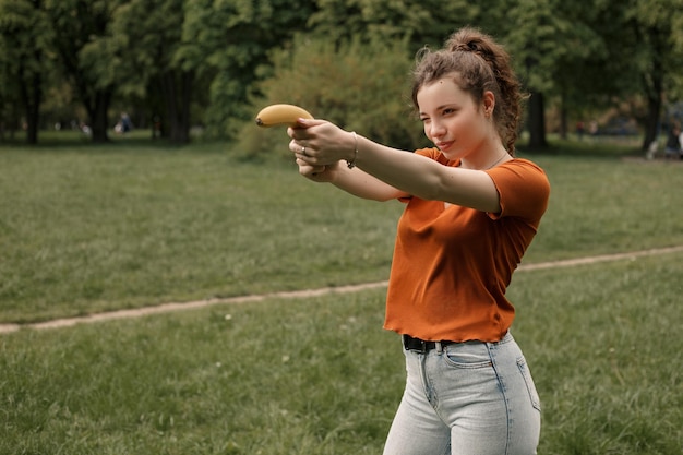 Foto mujer jugar con plátano en el parque