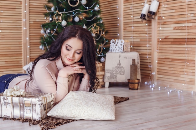 Mujer junto al árbol de Navidad