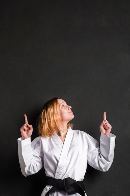 Mujer de Karate apuntando al espacio de copia