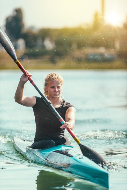 Mujer kayakista entrenando en el lago