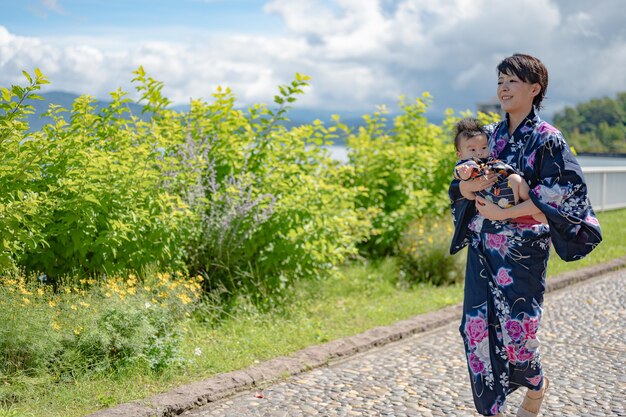 Una mujer con un kimono sostiene a un bebé en sus brazos.