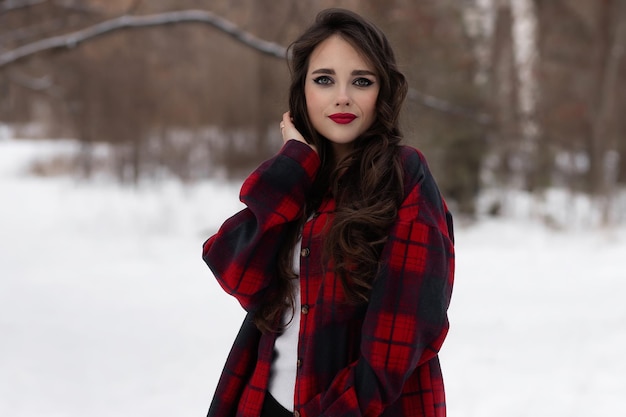 Mujer con labios rojos en bosque de invierno