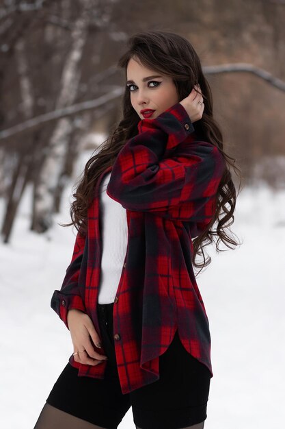 Mujer con labios rojos en bosque de invierno