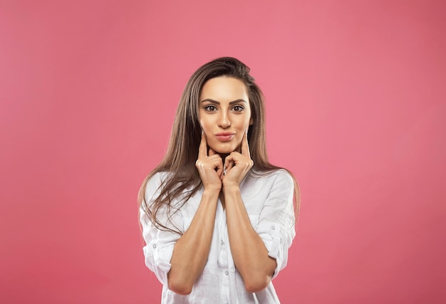 Mujer con labios rojos sorpresa sostiene las mejillas con la mano Hermosa chica con cabello largo sorprendida