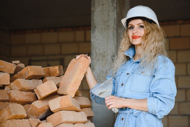 Mujer con ladrillo en concepto de construcción