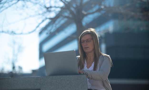 Mujer con laptop al aire libre en un espacio de oficina