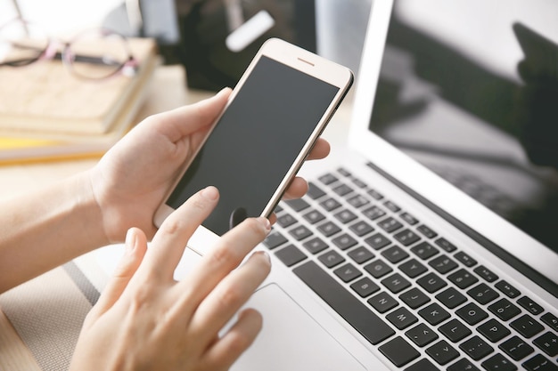 Mujer con laptop y celular en casa