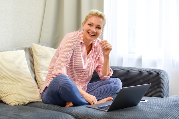 Mujer con laptop en el sofá trabajando