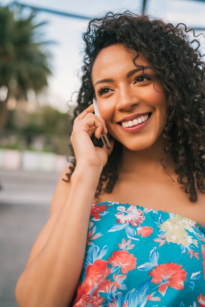 Mujer latina afroamericana hablando por teléfono