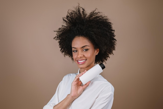 Mujer latina de belleza con peinado afro Mujer brasileña Sosteniendo envases de champú en blanco