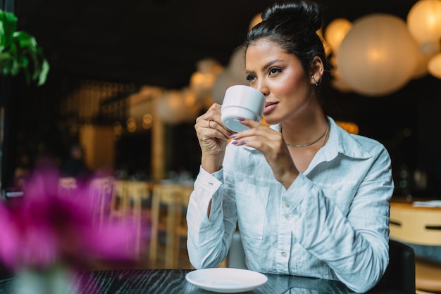 Mujer latina en un café bebiendo café