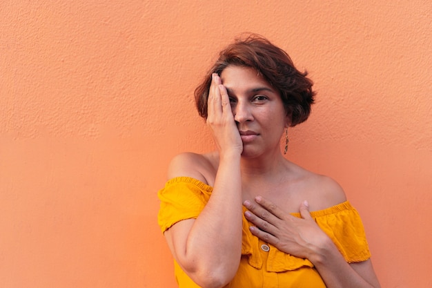 Mujer latina con fondo naranja colorido.