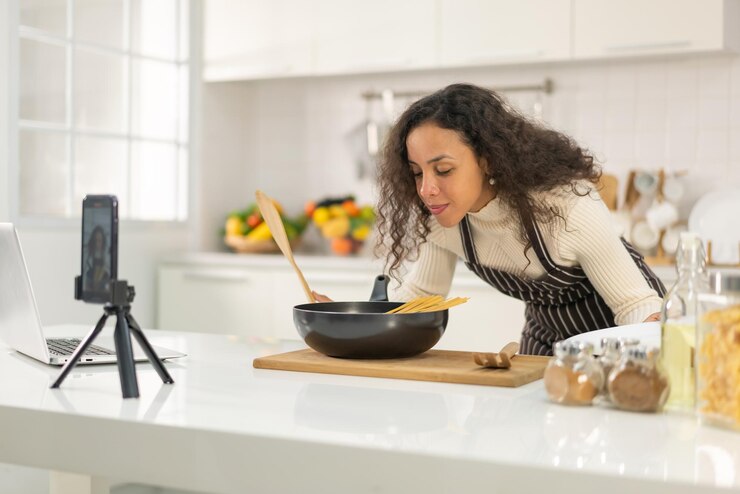 Foto mujer latina grabando video y cocinando en la cocina