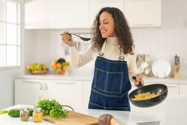 Foto mujer latina grabando video y cocinando en la cocina