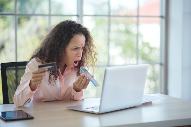 Mujer latina gritándole al empleado del banco No está contenta con el saldo de su tarjeta de crédito.