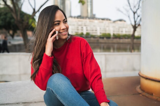 Mujer latina hablando por teléfono.