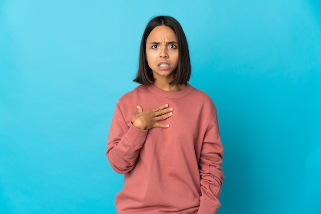 Mujer latina joven aislada en la pared azul apuntando a sí mismo