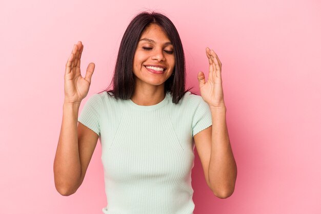 Mujer latina joven aislada sobre fondo rosa alegre riendo mucho. Concepto de felicidad.