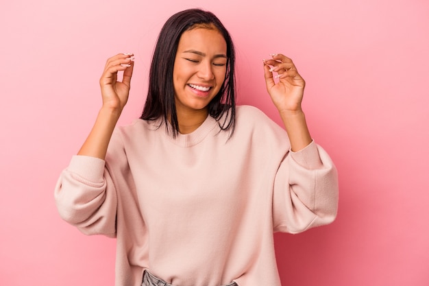 Mujer latina joven aislada sobre fondo rosa alegre riendo mucho. Concepto de felicidad.