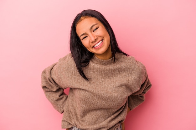 Mujer latina joven aislada sobre fondo rosa feliz, sonriente y alegre.