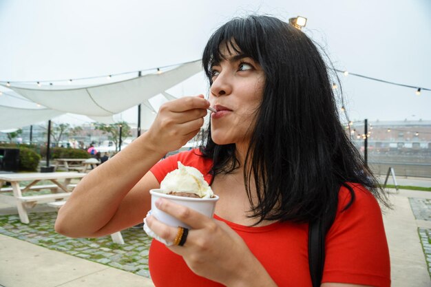 Mujer latina joven al aire libre comiendo helado