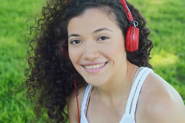 Mujer latina joven con los auriculares en un parque.