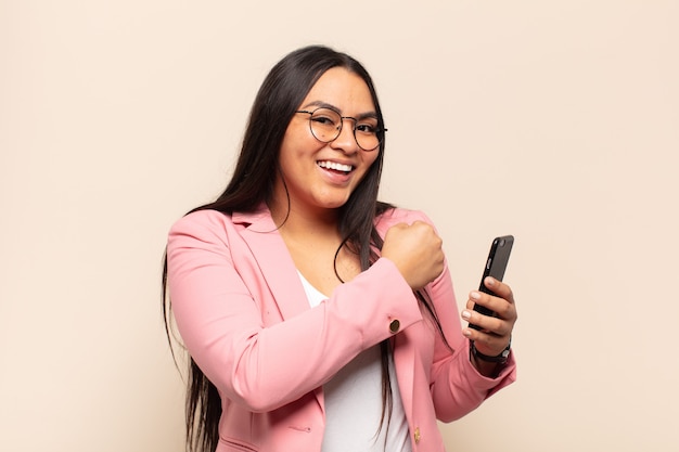 Mujer latina joven que se siente feliz, positiva y exitosa, motivada cuando enfrenta un desafío o celebra buenos resultados