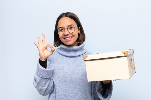 Mujer latina joven que se siente feliz, relajada y satisfecha, mostrando aprobación con gesto bien, sonriendo