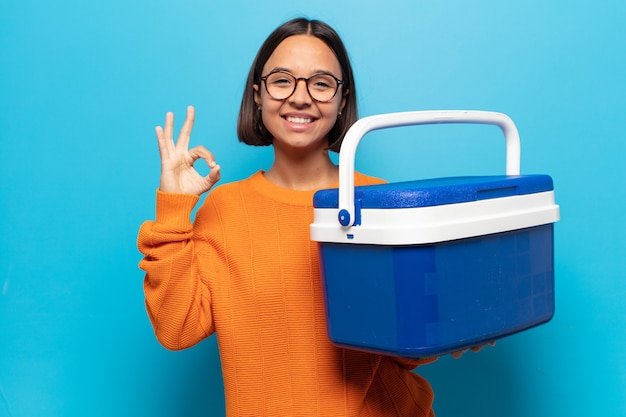 Mujer latina joven que se siente feliz, relajada y satisfecha, mostrando aprobación con gesto bien, sonriendo