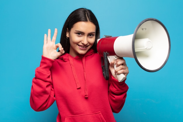 Mujer latina joven que se siente feliz, relajada y satisfecha, mostrando aprobación con gesto bien