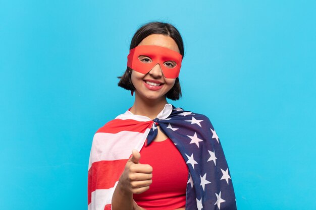 Mujer latina joven que se siente orgullosa, despreocupada, segura y feliz, sonriendo positivamente con los pulgares hacia arriba