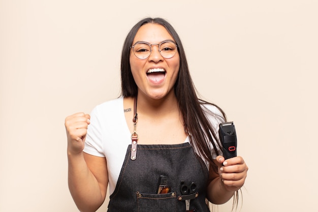 Mujer latina joven que se siente sorprendida, emocionada y feliz, riendo y celebrando el éxito, diciendo ¡guau!