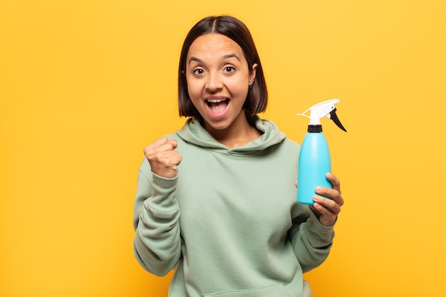 Mujer latina joven que se siente sorprendida, emocionada y feliz, riendo y celebrando el éxito, diciendo ¡guau!