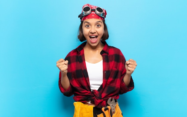 Mujer latina joven que se siente sorprendida, emocionada y feliz, riendo y celebrando el éxito, diciendo ¡guau!