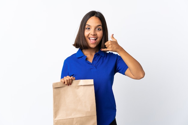 Mujer latina joven sosteniendo una bolsa de compras