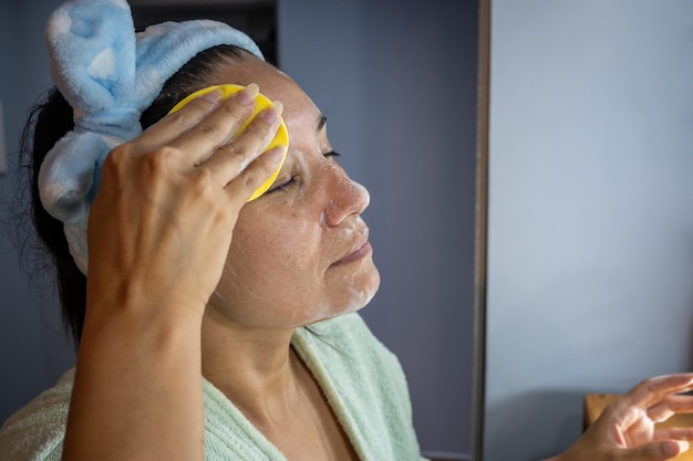 Foto mujer latina limpiándose la cara con espuma facial