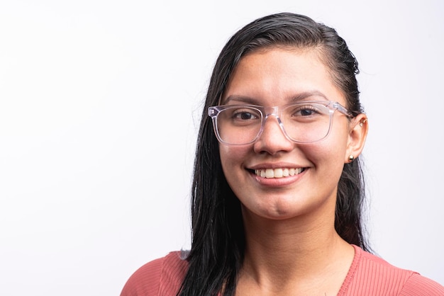 mujer latina morena sobre fondo blanco mirando a la cámara con gafas sonrientes